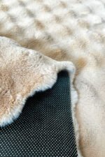 Close-up of the fluffy texture of a beige shaggy rug