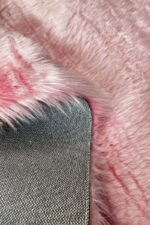 Close-up of the soft, thick pile of a pink shaggy rug
