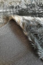 Close-up of the soft, thick pile of a grey shaggy rug