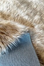 Close-up of the soft, thick pile of a brown shaggy rug