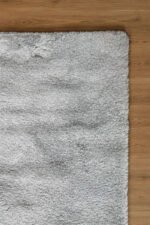 Close-up of the soft, thick pile of a grey shaggy rug