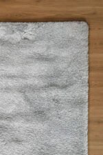 Close-up of the soft, thick pile of a grey shaggy rug