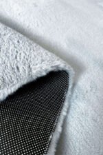 Close-up of the soft, thick pile of a grey shaggy rug
