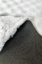 Close-up of the soft, thick pile of a grey shaggy rug