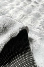 Close-up of the fluffy texture of a grey shaggy rug
