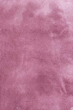 Detailed texture of a plush pink shaggy rug